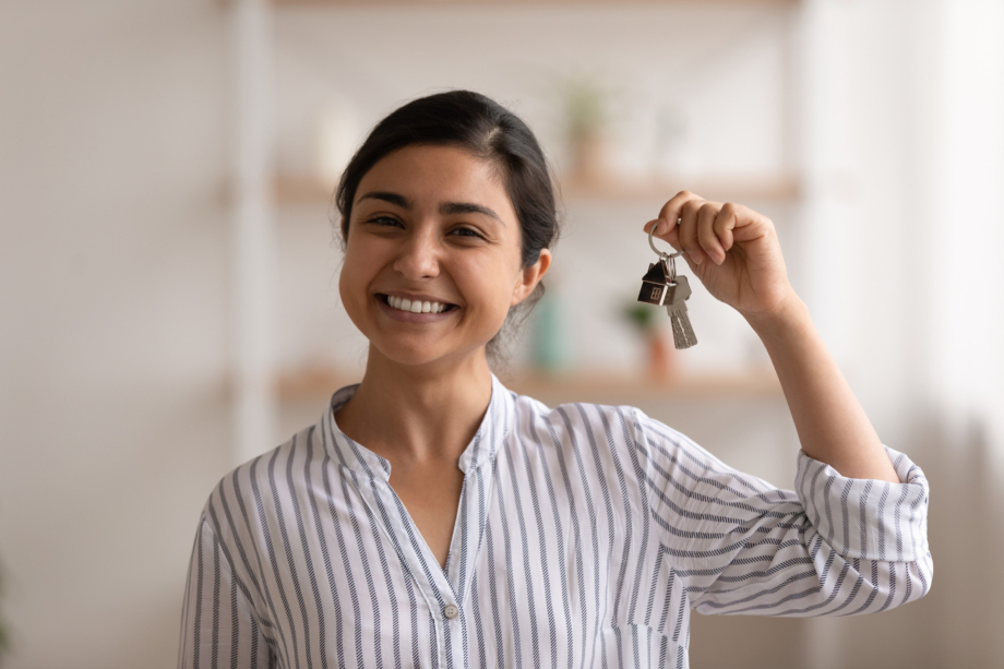 Smiling first home buyer holding house keys, representing successful mortgage approval and home ownership with Innovest financial advisers in New Zealand.