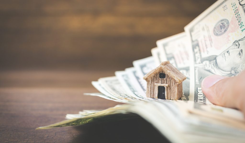 Money and house model on wooden background , Finance and banking concept.
